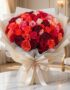 Impresionante bouquet de 72 rosas FILIPPA en tonos rojos, naranjas y rosas, con empaque coreano elegante, sobre mesa de mármo