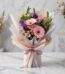 Bouquet Floral CARINA con gerberas y astromelias rosadas, lisianthus morados, envuelto en papel coreano elegante sobre mármol