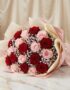 Bouquet ELETRA con 20 rosas rojas y rosadas, envuelto en papel coreano, sobre una superficie de mármol, ideal para regalar am