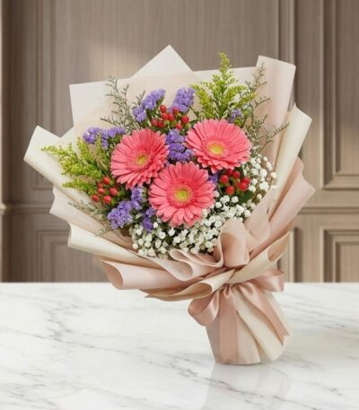 Bouquet Floral LIA con gerberas amarillas vibrantes, envuelto en papel coreano elegante, sobre una superficie de mármol pulid