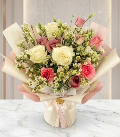 Bouquet Floral SUSANA con rosas blancas y rosadas, astromelias y follaje verde, envuelto en papel coreano rosa y crema, sobre