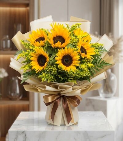 Bouquet de Girasoles LAIA con 10 flores frescas y radiantes, envuelto en papel coreano elegante y lazo marrón, sobre mármol b