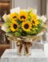 Bouquet de Girasoles LAIA con 10 flores frescas y radiantes, envuelto en papel coreano elegante y lazo marrón, sobre mármol b