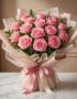 Bouquet Lionetta con 18 rosas rosadas frescas y abiertas, envuelto en papel coreano rosa y beige, sobre una mesa de mármol bl
