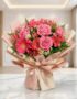 Bouquet ORLENA con rosas rosadas, gerberas fucsia y alstroemerias rojas, envuelto en papel coreano rosa claro sobre mármol bl