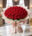 Imponente Bouquet PAOLA con 72 rosas rojas frescas y abiertas, envuelto en elegante empaque coreano, sobre mesa de mármol en
