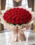 Imponente Bouquet PAOLA con 72 rosas rojas frescas y abiertas, envuelto en elegante empaque coreano, sobre mesa de mármol en