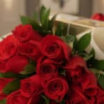 Primer plano extremo de un bouquet de rosas rojas con gotas de rocío, mostrando texturas hiperrealistas y colores vibrantes b