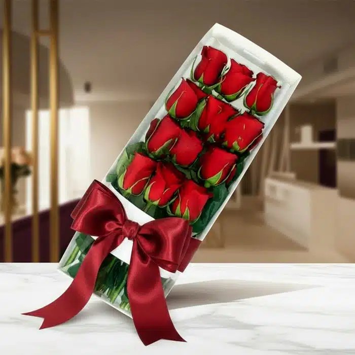 Caja de 12 Rosas Rojas: El Regalo Perfecto para Enamorar Caja de 12 rosas rojas frescas y vibrantes, presentadas en un elegante estuche blanco con un lazo de satén rojo, sobre una su