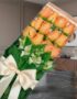 Caja de 12 rosas salmón frescas con follaje verde y alstroemerias blancas, presentadas en un empaque transparente con lazo be