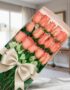 Caja de 18 rosas rosadas frescas y vibrantes con un elegante moño beige, presentadas en un fondo sofisticado y bien iluminado