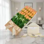 Caja de 18 rosas salmón frescas con follaje verde, presentada en una caja beige con lazo de satén y tarjeta de regalo en un s