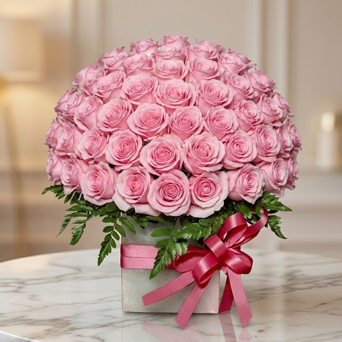 Caja floral Nadia con 72 rosas rosadas frescas y abiertas, dispuestas elegantemente en un arreglo grande y exuberante, con fo