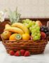 Canasta de mimbre con una variedad de frutas frescas como uvas verdes y rojas, plátanos, manzanas, peras, naranjas, kiwi, piñ