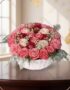 Cesta de Rosas Felicia con 21 flores bicolor, rosas rosadas y rojas, sobre una mesa de madera oscura con fondo elegante y luz