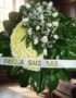 Corona fúnebre Descansa en Paz con rosas blancas y crisantemos amarillos, cinta personalizada, en sala de velación premium co