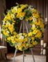 Corona fúnebre Legado de Paz para Benjamin, con rosas amarillas, flores blancas y follaje verde, exhibida en una sala de vela