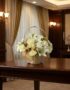 Cubre Caja Fúnebre Elizabeth, un hermoso arreglo floral en tonos blancos con lirios y rosas, presentado en una cesta de mimbr