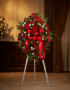 Pedestal fúnebre 'Homenaje Eterno a Andrés' con rosas rojas, claveles blancos y follaje verde, presentado en una elegante sal