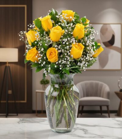 Jarrón de cristal con doce rosas amarillas vibrantes y follaje verde, sobre una superficie de mármol en un entorno de lujo.