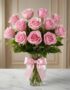 Jarron Allegria con doce rosas rosadas vibrantes y abiertas, adornado con un elegante moño rosa, sobre una superficie de márm
