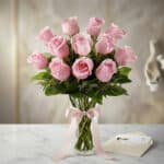 Jarron Allegria con 12 rosas rosadas frescas, cinta de satén rosa y tarjeta de regalo elegante sobre mármol blanco. Regalo pe