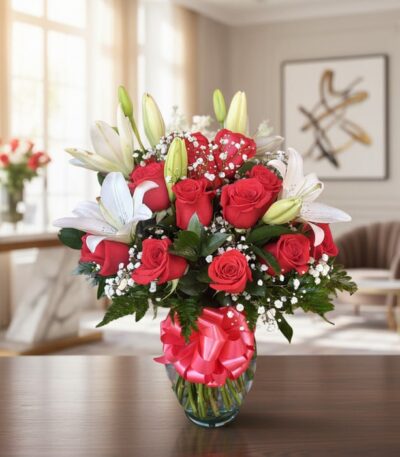 Jarrón Otoño con un elegante arreglo floral de rosas rojas vibrantes, lirios blancos puros y follaje verde, sobre una mesa de