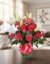 Jarrón Otoño con un elegante arreglo floral de rosas rojas vibrantes, lirios blancos puros y follaje verde, sobre una mesa de