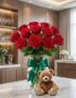 Jarrón Te Adoro con doce rosas rojas frescas y abiertas, lazo verde esmeralda, y un oso de peluche marrón sentado en una mesa