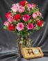 Jarrón Te Extraño con un hermoso arreglo de rosas rojas y rosadas, complementado con follaje verde y pequeñas flores blancas,