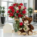 Jarrón Todo Para Ti con rosas rojas, lirios blancos, fresas y cerezas, acompañado de un osito de peluche con una rosa, una ta