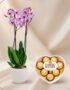 Arreglo floral premium Orquídea GALA con flores moradas y chocolates Ferrero Rocher en caja de corazón, ideal para regalo.