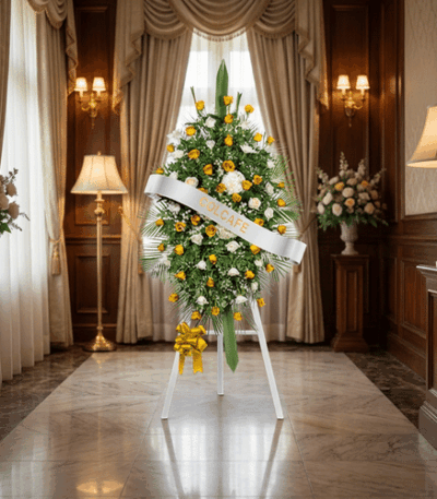 Pedestal fúnebre con rosas blancas y amarillas, ideal para honrar la memoria de un ser querido en una sala de velación elegan
