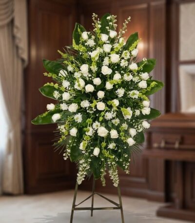 Pedestal fúnebre 'Nunca te Olvidaré' con rosas blancas, lirios y follaje verde, presentado en una sala de velación premium co