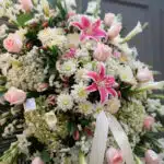 Fotografía macro premium del Pedestal Fúnebre Pasión, mostrando texturas hiperrealistas de rosas, lirios y follaje con rocío