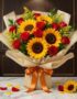 Ramillete o Bouquet Primavera con girasoles grandes y rosas rojas abiertas, envuelto en papel coreano elegante, sobre mármol.