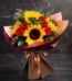 Ramo Aurora de rosas rojas y girasoles vibrantes, envuelto elegantemente en papel de tonos tierra y atado con un lazo de saté