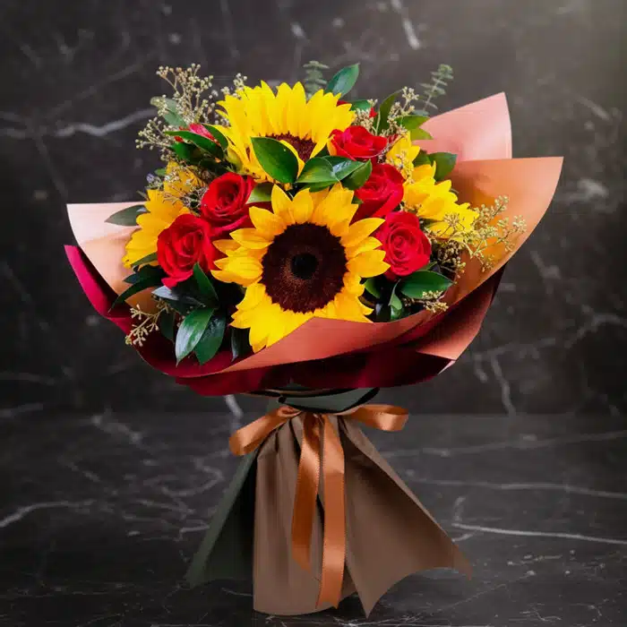 Ramo Aurora: Rosas Rojas y Girasoles Vibrantes para Alegrar el Día Ramo Aurora de rosas rojas y girasoles vibrantes, envuelto elegantemente en papel de tonos tierra y atado con un lazo de saté
