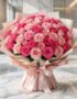 Impresionante ramo de 60 rosas fucsia y rosadas, con empaque coreano elegante, sobre mesa de mármol en floristería premium.