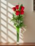 Arreglo floral Solitario con Rosas Marilyn en un jarrón de cristal, sobre una superficie de mármol pulido, con un fondo elega