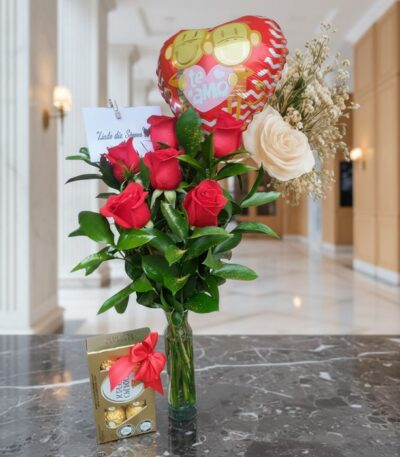 Arreglo floral Solitario con Rosas Me Enamoras, rosas rojas y una rosa blanca, follaje verde, globo de corazón 'Te Amo' y caj