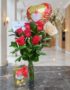Arreglo floral Solitario con Rosas Me Enamoras, rosas rojas y una rosa blanca, follaje verde, globo de corazón 'Te Amo' y caj