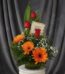 Arreglo floral 'Solitario Tu Recuerdo' con tres rosas rojas, tres gerberas naranjas, follaje verde y flores blancas pequeñas,